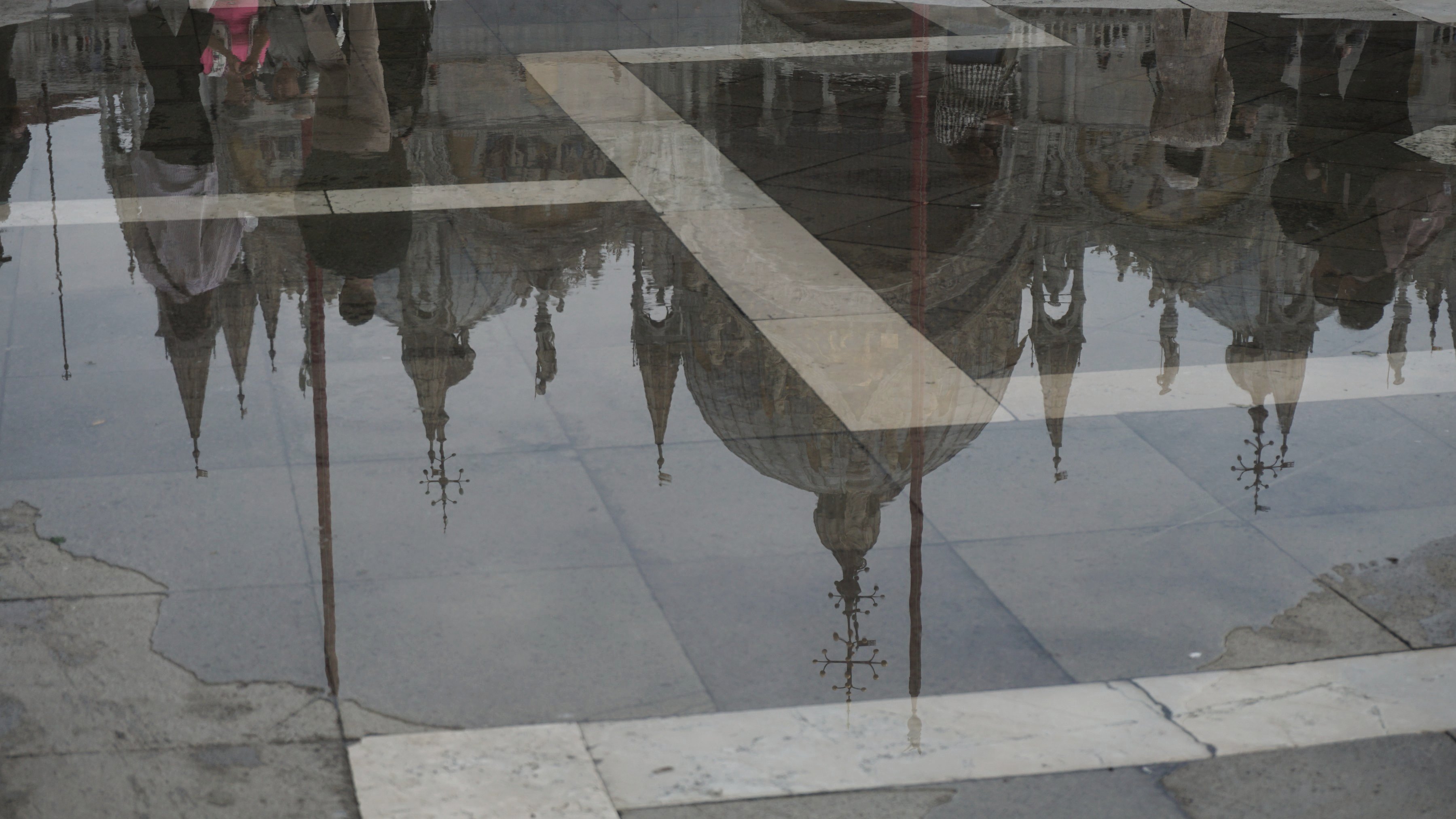 Venedig: Türme des Markusdomes spiegeln sich in Wasser auf dem Platz.